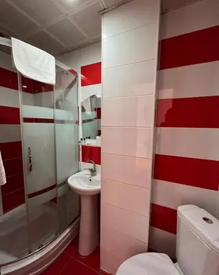 a red and white bathroom with a toilet and a sink at Red White Hotel in Istanbul