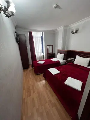 a hotel room with two beds with red sheets at Red White Hotel in Istanbul