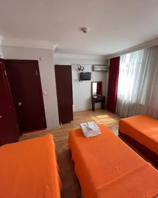 a hotel room with two beds with orange sheets at Red White Hotel in Istanbul