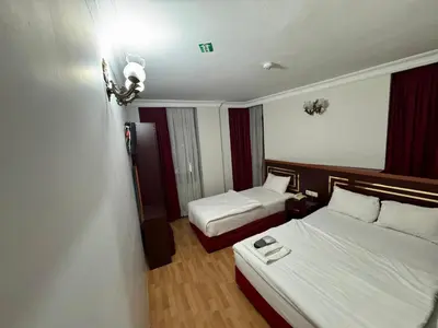 a hotel room with two beds and a light on the wall at Red White Hotel in Istanbul