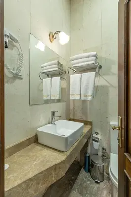 a bathroom with a sink and a mirror and towels at Bursa Grand Family HOTEL in Bursa