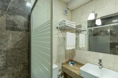 a bathroom with a sink and a toilet and a mirror at Bursa Grand Family HOTEL in Bursa