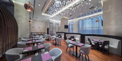 a restaurant with tables and chairs and lights at Doubletree by Hilton Istanbul Umraniye in Istanbul