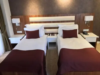 a hotel room with two beds and two tables at Endglory Hotel in Corlu