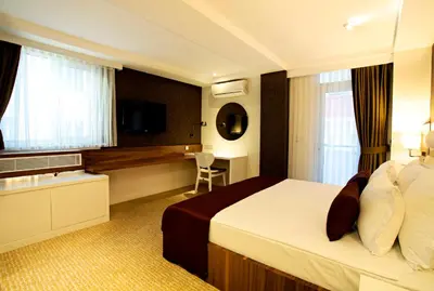 a hotel room with a bed and a desk at Endglory Hotel in Corlu