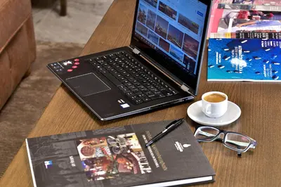 a laptop computer sitting on a table with a book and a cup of coffee at Adelmar Hotel Istanbul Sisli in Istanbul