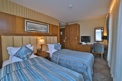 a hotel room with two beds and a desk at Adelmar Hotel Istanbul Sisli in Istanbul