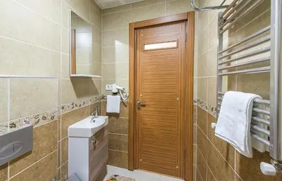 a bathroom with a sink and a wooden door at Green Life Apart Hotel in Istanbul