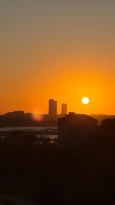 a sunset with the sun setting in a city at Green Life Apart Hotel in Istanbul