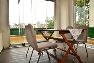 a table and chairs in a room with a large window at Hande Hotel in Mustafakemalpaşa