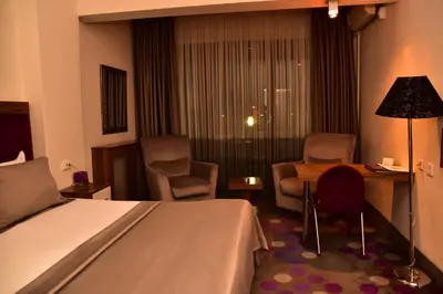 a hotel room with a bed and a desk and chairs at Hande Hotel in Mustafakemalpaşa