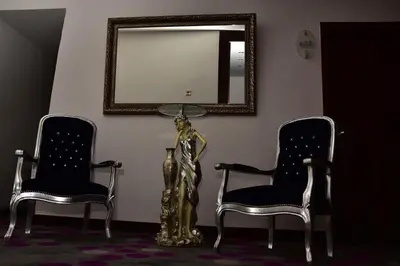 two chairs and a statue in a room with a mirror at Hande Hotel in Mustafakemalpaşa