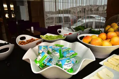 a table with bowls of fruit and other bowls of food at Hande Hotel in Mustafakemalpaşa