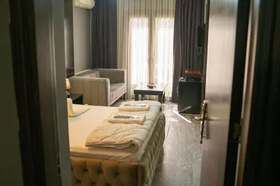 a bedroom with a bed and a living room at Ömer Agah Istanbul Hotel Bayrampasa in Istanbul