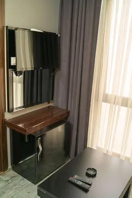 a room with a desk with a television and a table at Ömer Agah Istanbul Hotel Bayrampasa in Istanbul