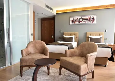 a bedroom with two beds and two chairs at The Elegant Hotel in Istanbul