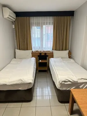 a hotel room with two beds and a desk at Hotel Semih in Istanbul