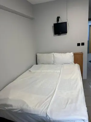 a bed with white sheets and a tv on the wall at Hotel Semih in Istanbul