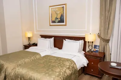 a hotel room with two beds and a table at Anemon Koleksiyon Galata Otel in Istanbul