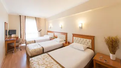 a hotel room with two beds and a desk at Prestige Hotel Old City in Istanbul
