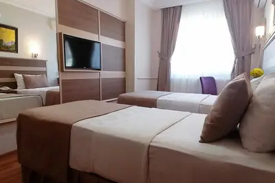 a hotel room with two beds and a flat screen tv at Sembol Hotel in Istanbul