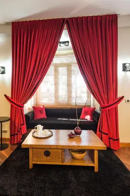 a living room with red curtains and a coffee table at Taxim Suites Residences Istanbul in Istanbul