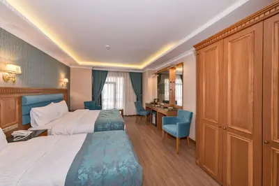 a hotel room with two beds and a desk at Magnaura House Hotel in Istanbul