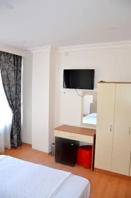 a hotel room with a bed and a desk and a tv at Baran Home Aparts in Istanbul