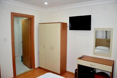 a bedroom with a bed and a tv on the wall at Baran Home Aparts in Istanbul