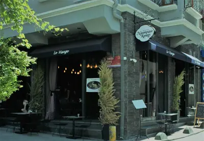 a restaurant with tables and chairs in front of a building at Hotel Naumpasa Konagi in Istanbul