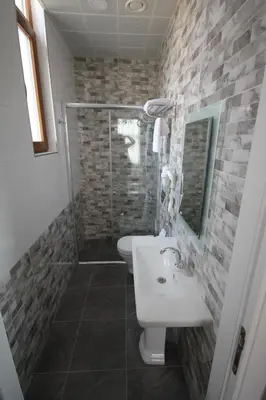 a bathroom with a toilet and a sink and a shower at Hotel Naumpasa Konagi in Istanbul