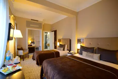 a hotel room with two beds and a living room at City Center Hotel Taksim İstanbul in Istanbul