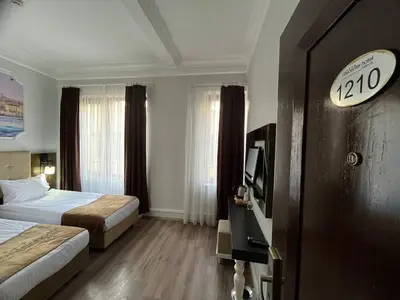 a hotel room with two beds and a flat screen tv at City Center Hotel Taksim İstanbul in Istanbul