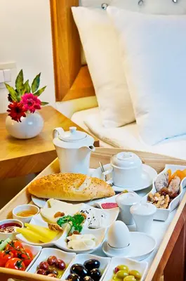 a tray of breakfast foods on a table with a bed at Tugcu Hotel Select in Bursa