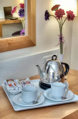 a tea kettle and two cups on a table at Tugcu Hotel Select in Bursa
