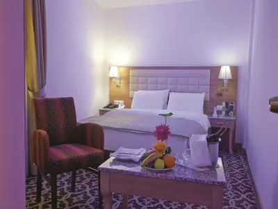 a hotel room with a bed and a table with a bowl of fruit at The City Hotel in Istanbul