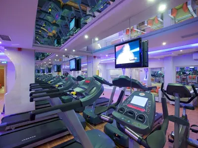 a gym with a bunch of treadmills and a tv at The City Hotel in Istanbul