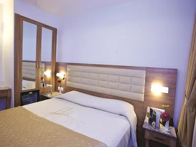 a bedroom with a large bed and a mirror at The City Hotel in Istanbul