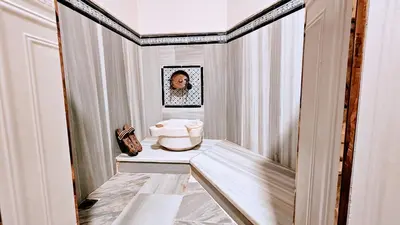 a hallway with a sink and a woman in a mirror at Otantik Hotel & Spa in Bursa