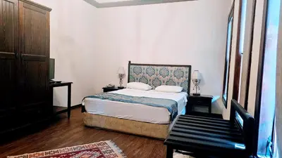 a bedroom with a bed and a bench in it at Otantik Hotel & Spa in Bursa