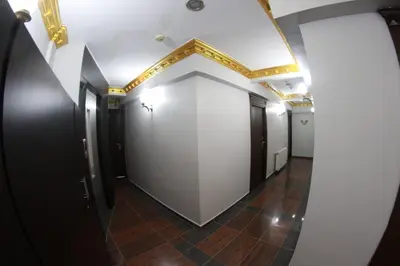 a hallway with a white wall with a gold ceiling at Ares Hotel in Istanbul