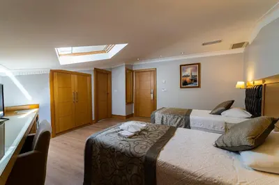 a hotel room with two beds and a skylight at Levent Hotel Istanbul in Istanbul