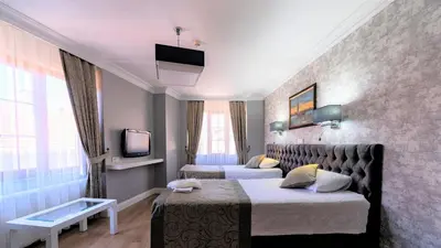 a hotel room with two beds and a tv at Levent Hotel Istanbul in Istanbul