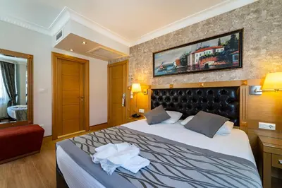 a hotel room with a bed and a red couch at Levent Hotel Istanbul in Istanbul