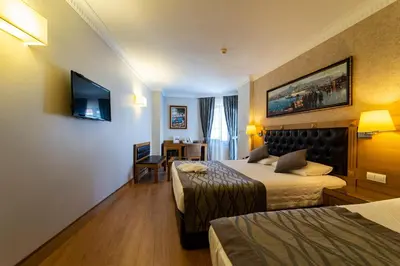 a hotel room with two beds and a television at Levent Hotel Istanbul in Istanbul