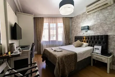 a hotel room with a bed and a desk and a television at Levent Hotel Istanbul in Istanbul
