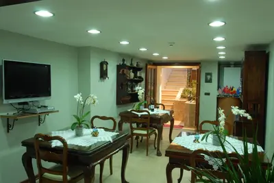 a living room with tables and chairs and a television at Villa Sphendone Suites Istanbul in Istanbul