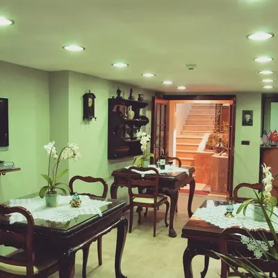 a living room with tables and chairs and a staircase at Villa Sphendone Suites Istanbul in Istanbul