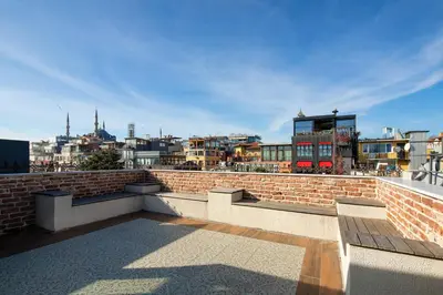a brick wall with benches and a city in the background at Tria Elegance Istanbul in Istanbul