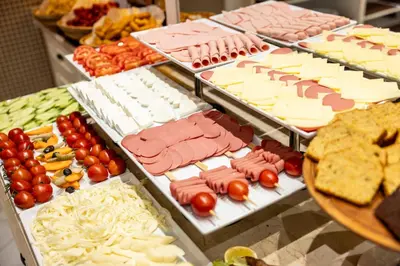 a buffet filled with cheese and meats and other foods at Raymond Hotel Old City in Istanbul